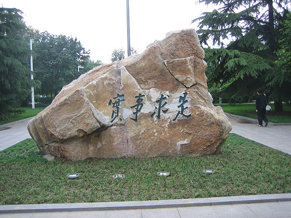 The rock holding the engraved motto of the university, "seeking truth from facts"