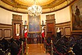 salón del Cabildo del Ayuntamiento de México. Nótese el escritorio central que tiene un escudo antiguo.