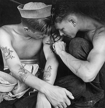Sailor being tattooed by a fellow sailor aboard USS New Jersey in 1944