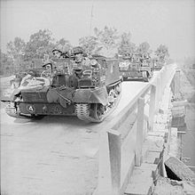 Universal Carriers of the 1st Battalion, Grenadier Guards cross 'Euston Bridge' as they deploy for Operation 'Goodwood', 18 July 1944. The British Army in the Normandy Campaign 1944 B7526.jpg