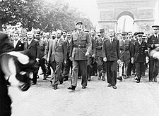 General de Gaulle and his entourage proudly stroll down the Champs Élysées to Notre Dame Cathedral for a Te Deum ceremony following the city's liberation on 25 August 1944.