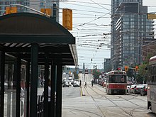 Southbound streetcars from the 510 Spadina line enters CityPlace. The 510 Spadina is one of three streetcar lines that operate in the area. The two Flexity Outlooks in service on 2014 08 31 pass on the railway bridge south of Front. (2) (15110060092).jpg