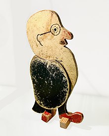 Small wooden toy depicting a bearded man with round glasses.