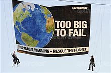 On his first day as Greenpeace executive director, Radford participated in a protest of government inaction on climate change at the State Department. Too big to fail Greenpeace banner Phil Radford.jpg