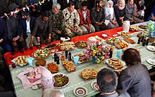 Typical Afghan food table US Army (USA) Colonel (COL) Kevin McDonnell (background center), Commander, 1ST Battalion, 3rd Special Forces Group (SFG) and Afghanistan National Army (ANA) COL Nahji Bulla (to COL McDonnells right) were special guest at a lunch.jpg