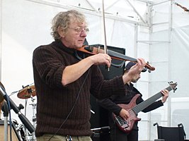 Jan Hrubý standing onstage with another musician, playing a violin