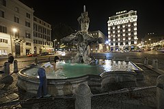 A young woman drinking from the fountain in Piazza Bernini, Rome, Italy