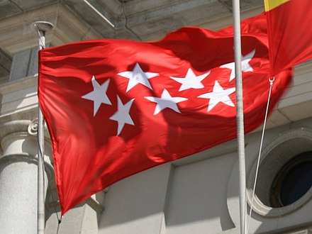 Flag of the Community of Madrid waving at the outdoors of a building