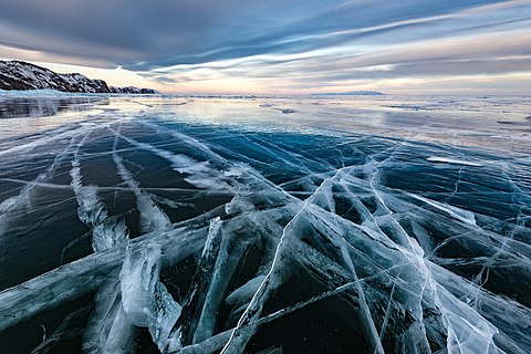 Transparent black ice of Baikal lake near Olkhon island.