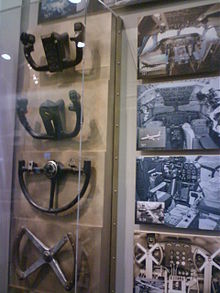 Collection of control yokes at Boeing Future of Flight Museum: 747, 707, B-29, Trimotor. The former two yokes are W-shaped, while the latter two are circular. BoeingControlYokes.jpg