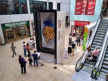 A variant of the Corpus Clock in the Lion Yard atrium in June 2019 Cmglee Cambridge Lion Yard Chronophage.jpg