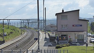 Two-story building next to double-track railway line with side platforms