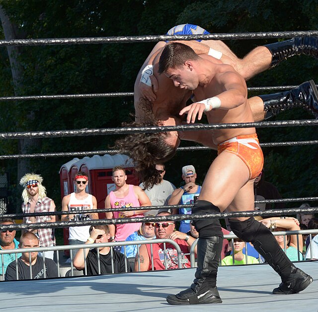 Newcomers, Flip Gordon and Brick Mastone wrestle at an outdoor event in 2015 to benefit wounded vets.