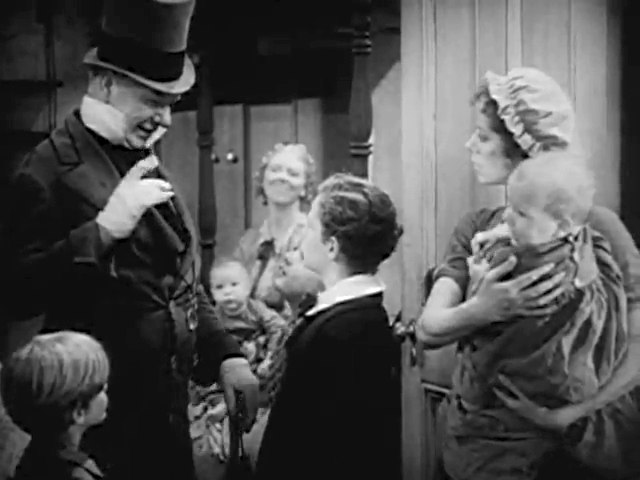 Mr. Micawber (played by W. C. Fields) addresses young David Copperfield (Freddie Bartholomew).