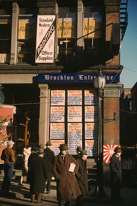 Headlines posted in street-corner window of newspaper office (Brockton Enterprise), 60 Main Street, Brockton, Massachusetts, December 1940. Additionally upstairs, the first main offices of W.B. Mason.