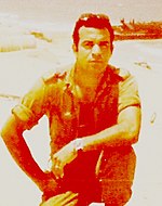 סרן גבי שילה מפקד בסיס דפנה על רקע המעגן הנבנה בחוף 1976