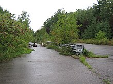 An unused section of divided highway approaching Interstate 189 in Burlington, Vermont (looking southward from:
.mw-parser-output .geo-default,.mw-parser-output .geo-dms,.mw-parser-output .geo-dec{display:inline}.mw-parser-output .geo-nondefault,.mw-parser-output .geo-multi-punct,.mw-parser-output .geo-inline-hidden{display:none}.mw-parser-output .longitude,.mw-parser-output .latitude{white-space:nowrap}
44deg26'57''N 73deg13'3''W / 44.44917degN 73.21750degW / 44.44917; -73.21750); some lanes are now blocked by discarded electronics; VTDOT has since begun work to make this segment part of Champlain Parkway. Ghostrampbtv.JPG