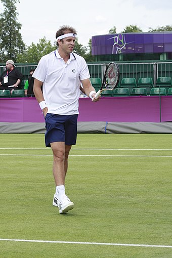 Gilles Müller sur un court en gazon du All England Lawn Tennis and Croquet Club, lors du deuxième tour des Jeux olympiques.