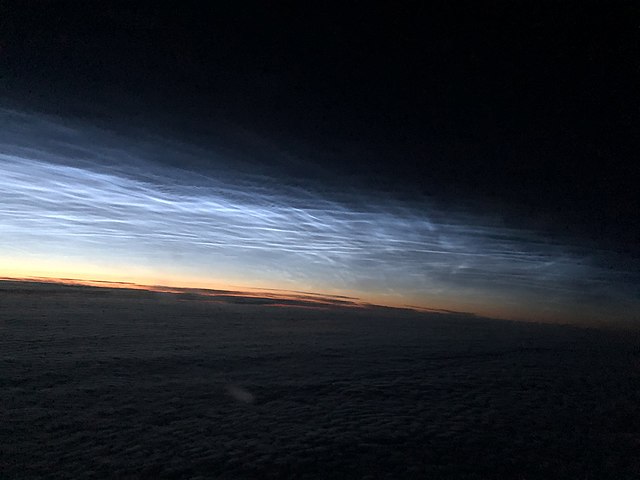 Noctilucent clouds during arctic dawn seen from high altitude