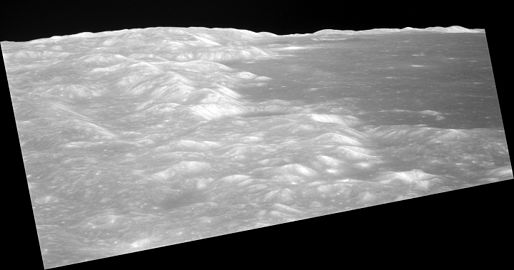 Low-altitude view of southern Mare Crisium from Apollo 11, facing northwest and showing the crater Shapley near center at the edge of the mare, and the distal wall of the crater Greaves near the horizon.
