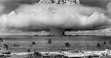 Ядерный гриб и столб воды, поднятые при надводном ядерном испытании 25 июля 1946 года. Фотография сделана с башни на атолле Бикини в 3,5 милях (5,6 км) от взрыва.