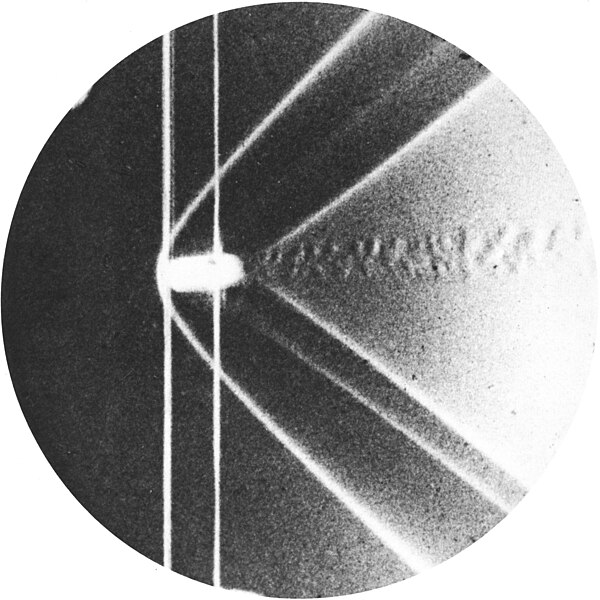 Schlieren photograph of the detached shock on a bullet in supersonic flight, published by Ernst Mach and Peter Salcher in 1887