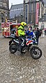 A Dutch police officer talking to an older woman wearing a headscarf.