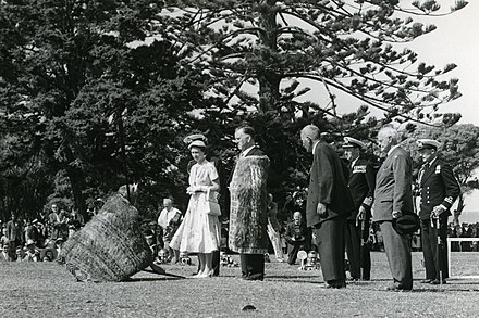 Queen Elizabeth II being greeted with a Māori ceremony (a pōwhiri) before addressing a crowd. Waitangi, December 1953