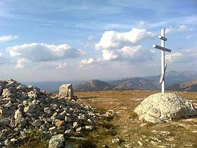 Pohled z vrcholu římského Kochu: Pravoslavný kříž se tyčí u ruin staré byzantské kaple.