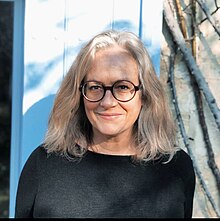 une femme avec des lunettes et des cheveux blancs.