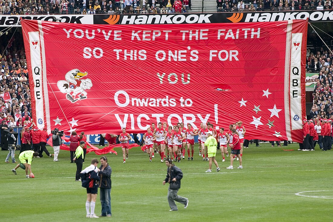 File:Sydney break through their banner, 2005 AFL Grand Final.jpg