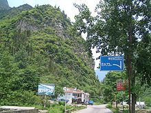 Junction with a Hubei provincial highway in Baishahe Village, Nanyang Town, Xingshan County, Hubei. For the next 52 km to the north (to Muyu) G209 will follow the Xiangping River, doubling as part of the Yichang-Shennongjia Highway; for the 72 km to the southwest, it will be crossing two mountain ranges to get to Badong VM 5169 Xingshan County Baishahe Village.jpg