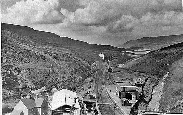 The line in 1951 before electrification, looking westwards from above Woodhead Tunnel. Woodhead railway station is visible in the foreground.