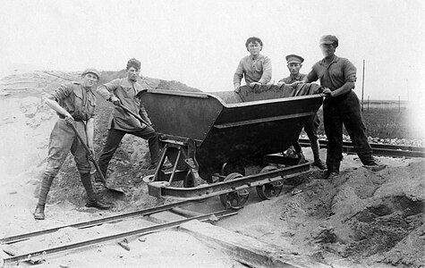 קבוצת פועלים בעת העברת חומר מהמחצבה למפעל נשר למלט. צולם בשנות ה-20 של המאה ה-20.