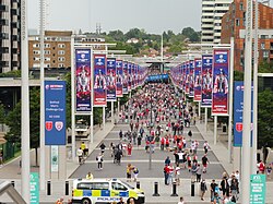 Looking down onto the Olympic Way from the Wembley Stadium steps, where a Metropolitan Police carrier van is also seen passing.