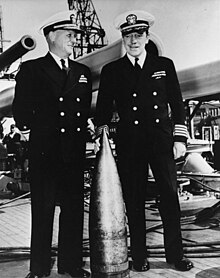 Rear admiral Carleton F. Bryant (left) and Captain Charles A. Baker, Commanding Officer of USS Texas aboard with a German 240mm (9.4) dud shell that hit the ship during the bombardment of Battery Hamburg, east of Cherbourg, France, on 25 June 1944. 80-G-46961 Rear Admiral Carleton F. Bryant, USN.jpg