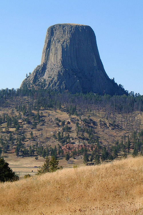 Devils Tower, United States, an igneous intrusion exposed when the surrounding softer rock eroded away