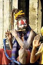 A sadhu playing flute