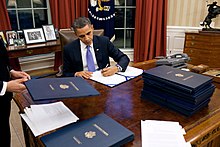 Barack Obama signing with his left hand BarackObamaSigningLegislation.jpg