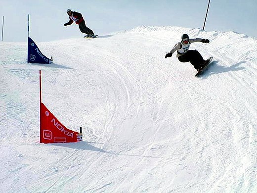 Twee snowboarders tijdens een snowboardcross