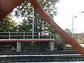 The Port Jeff-Greenport bound platform as seen through a rusty chain-link fence.