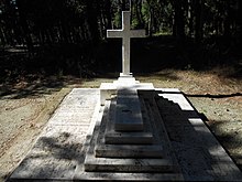 Croix latine entourée de deux pierres tombales.