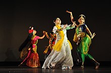 Quatre femmes portant un sari dans différentes poses de danse