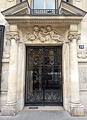 Metal and glass door between a pair of Ionic columns, in Paris