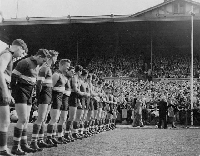 Footscray players line up for the unfurling of the 1954 VFL Grand Final premiership flag