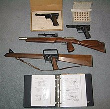 The Gyrojet family: two Gyrojet pistols, a carbine and the rifle. In the top-right corner is a box of 13 mm Rockets, and at the bottom is a diagram book for the guns. Gyrogroup.jpg