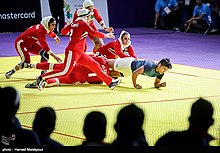 An Indian kabaddi player struggling to escape a tackle during the 2018 Asian Games kabaddi final won by Iran. Kabaddi is a traditional South Asian game which is growing globally. Iran women's national kabaddi team 1397060223024359515137374.jpg