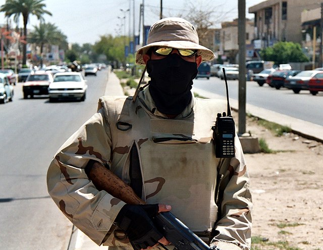 An armed Iraqi interpreter on patrol with U.S. troops on the streets of Baghdad. They became frequent targets of insurgents during the war.