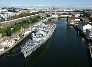 The helicopter-carrier Jeanne d'Arc docked on the left bank of the Penfeld, downstream of the pont de l'Harteloire. The high-tides are too low for ships to be able to dock nearer to the quays, which are still all along the river. In the background, the eglise Saint-Louis, to the right, the viaduct of the "grue revolver," a former crane that looked like a pistol. Jeanne D Arc 4.jpg