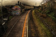 The station building at Montpelier is not in railway use, and is covered in a community-painted mural. The northern platform (right) is disused.